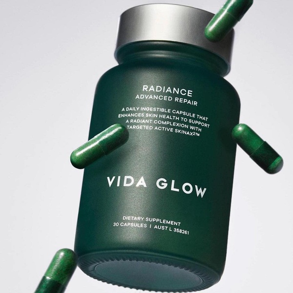 A high-end 1:1 square ad featuring a floating bottle of dietary supplement surrounded by suspended capsules against a neutral studio backdrop.